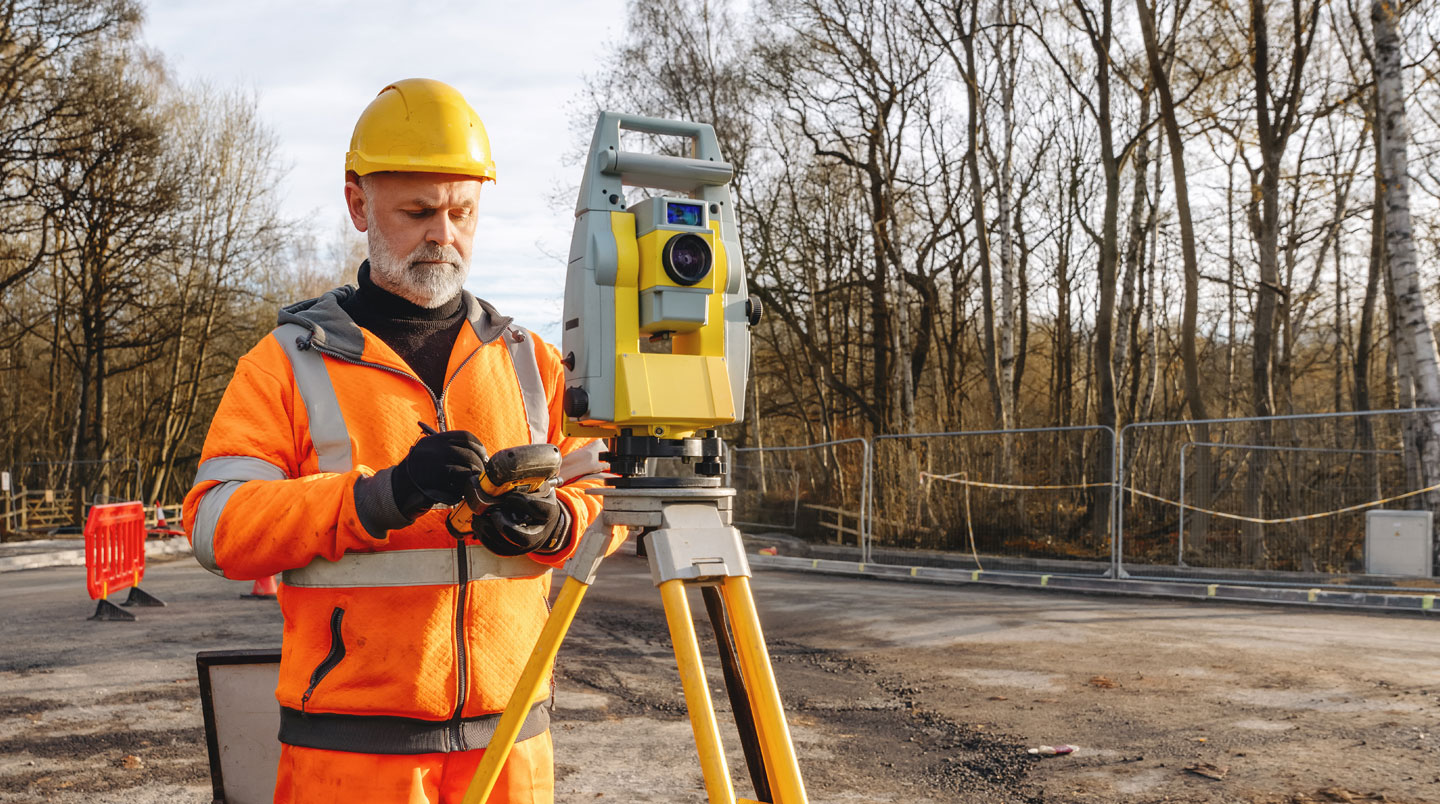 Responsable urbanisme examinant l'installation d'un panneau municipal avec tablette en main, contexte d'audit terrain